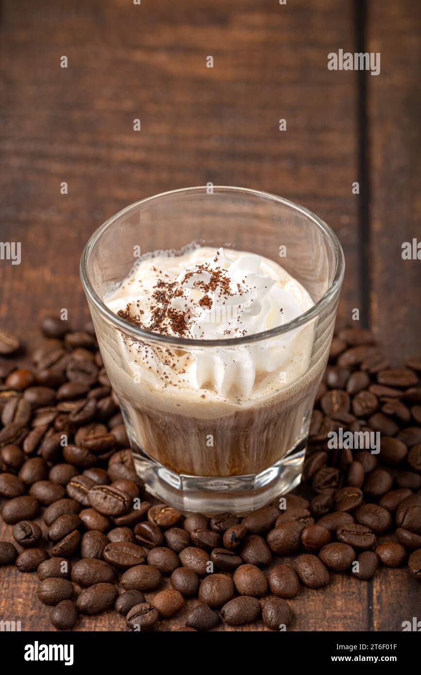 Hot espresso con panna in glass cup on wooden table Stock Photo