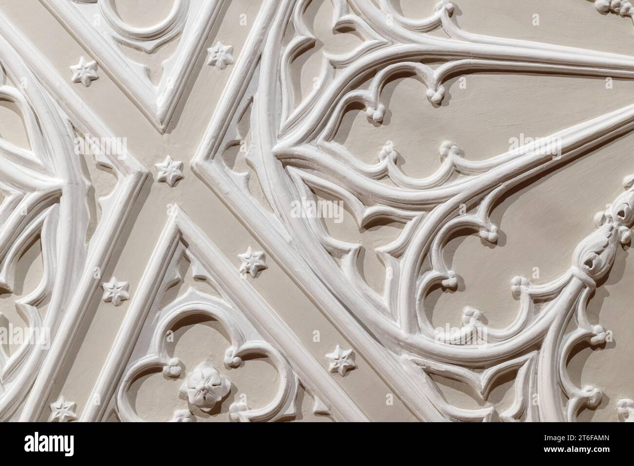 White gypsum bas-relief ceiling design details over beige background. Classic architecture abstract template, Gothic style Stock Photo