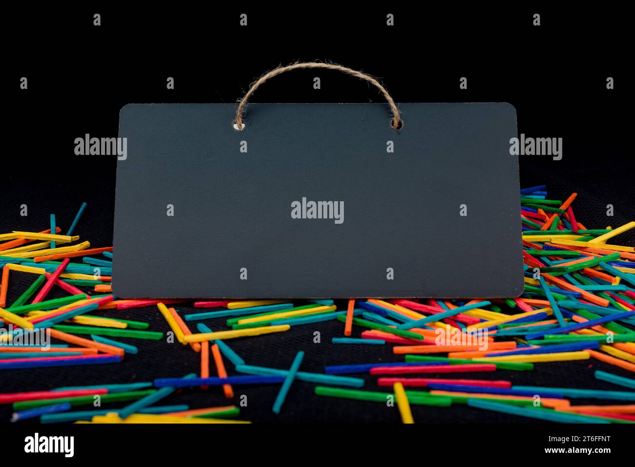 Rectangular shaped black notice board on colorful sticks on black Stock Photo