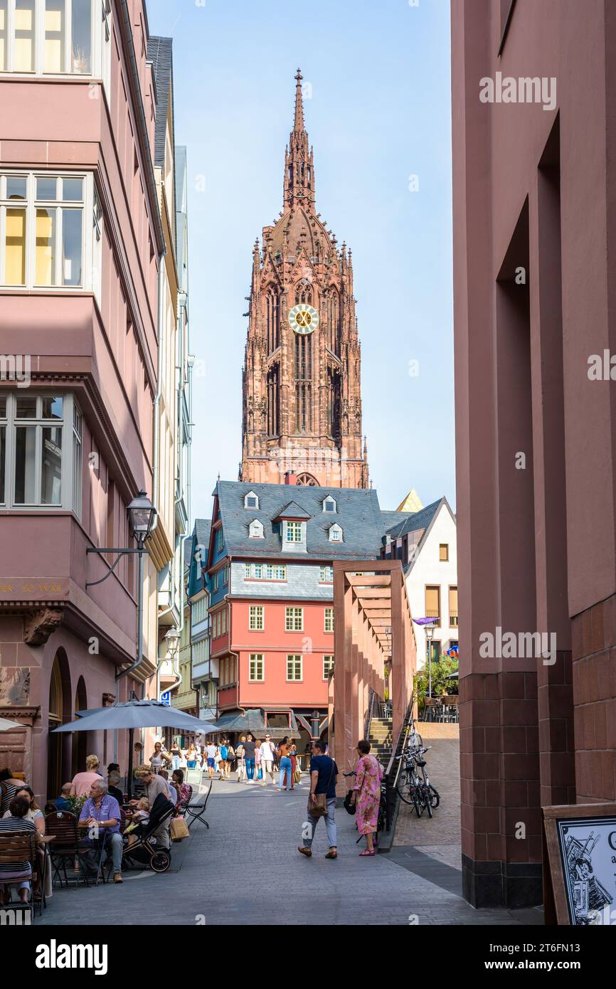 The bell tower of Frankfurt Cathedral overlooks the medieval townhouses and narrow streets of the Altstadt with sidewalk cafes frequented by tourists. Stock Photo