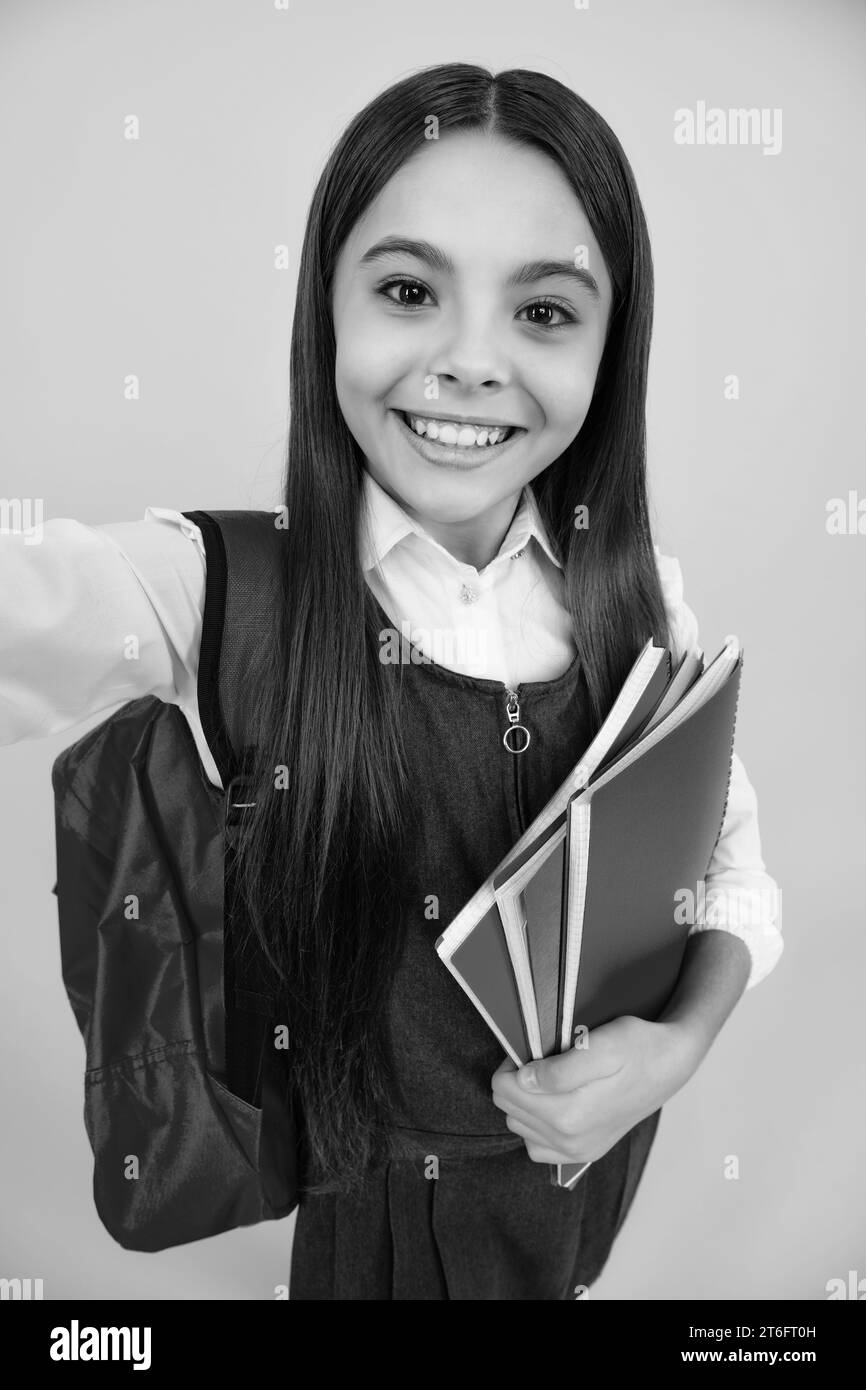 School teenage girl with school bag backpack hold book on yellow