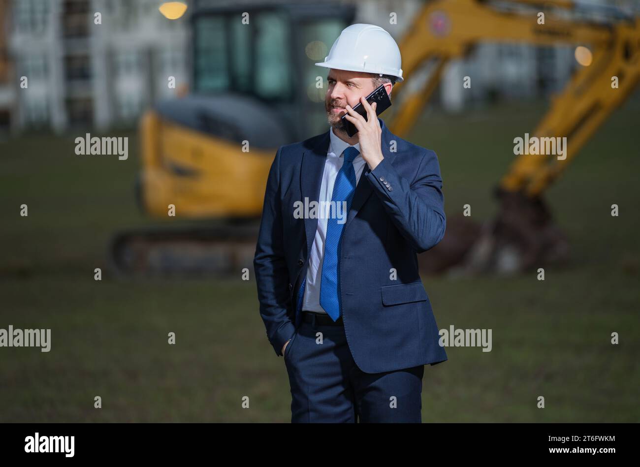 Construction manager in suit and helmet at a construction site. Construction manager worker or supervisor wearing hardhat in front of house. Superviso Stock Photo