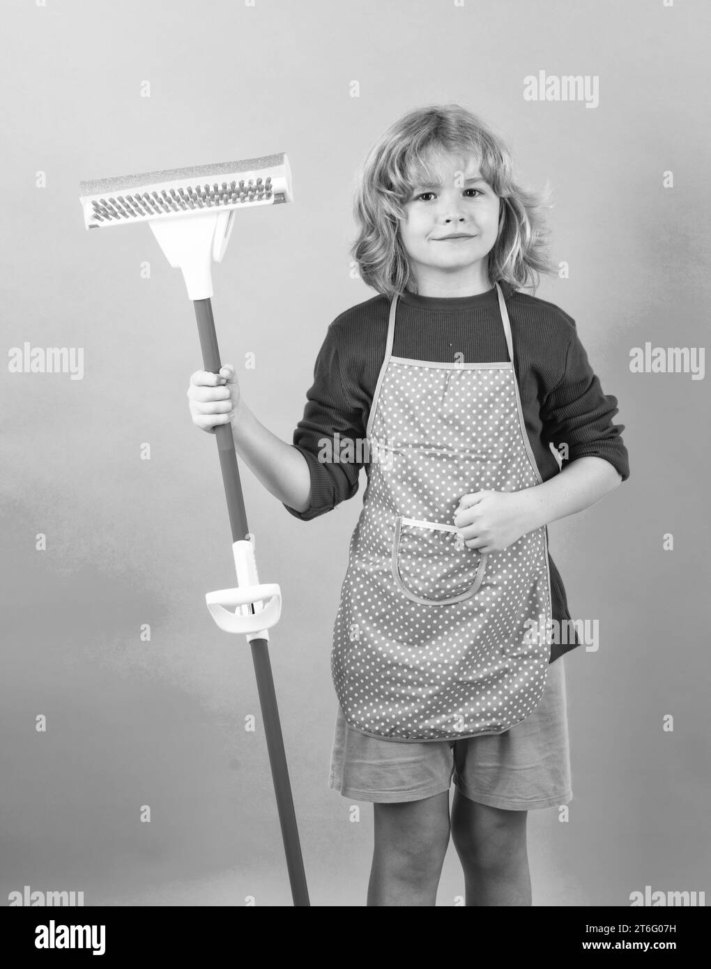 Child doing housework. Portrait of child cleaning, concept growth, development, family relationships. Housekeeping and home cleaning concept. Stock Photo