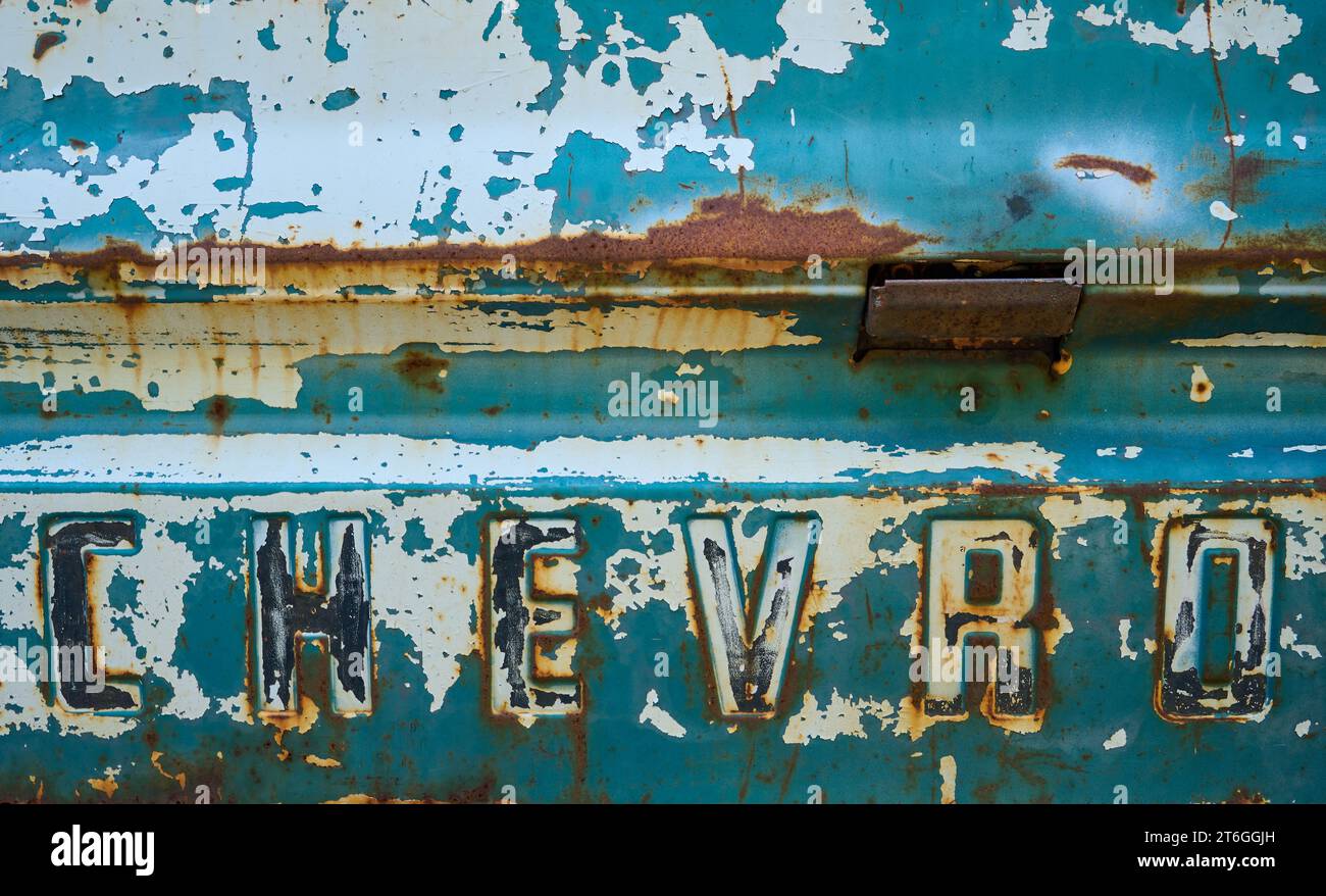 Detail shot of the tailgate of a rusty Chevrolet pickup truck. Stock Photo