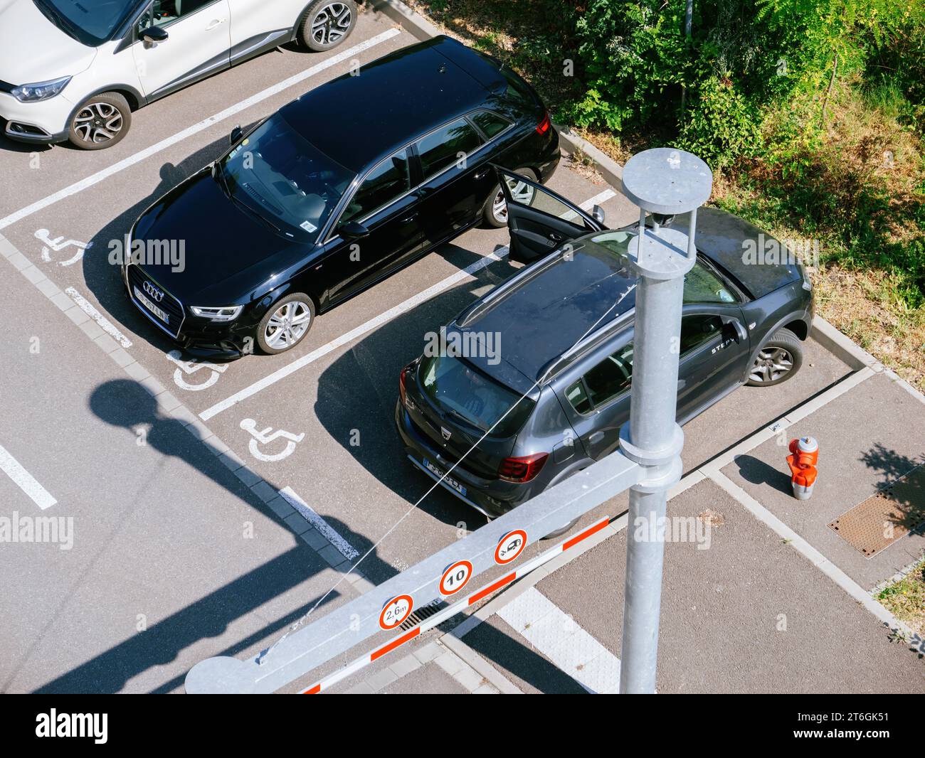 Strasbourg, France - May 5, 2023: An aerial view of two cars improperly parked in spaces designated for disabled parking, with no visible disability permits Stock Photo