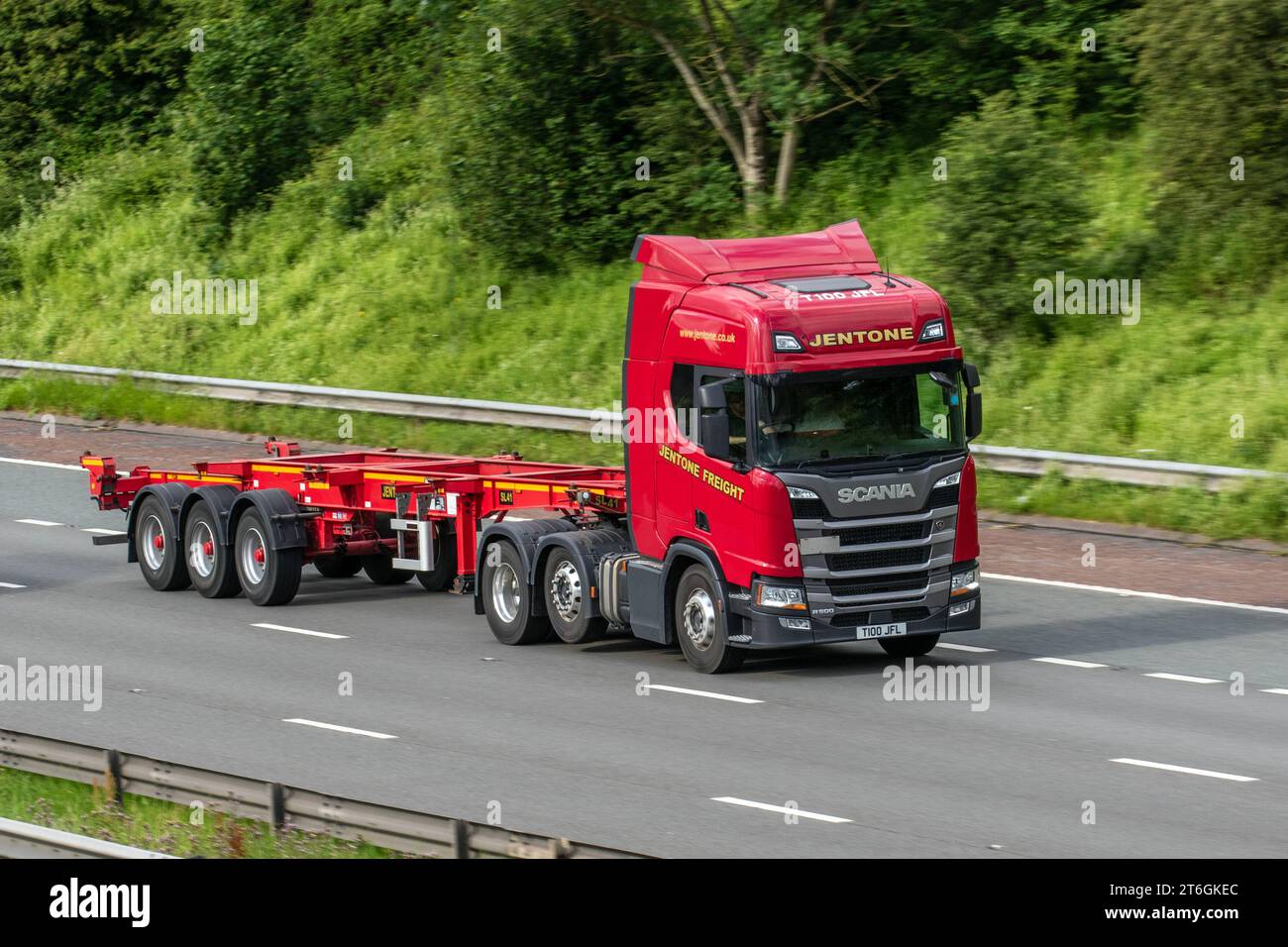 Jentone Freight Limited trucking company  Scania R500 Jentone Freight Limited, empty articulated tri-axle flatbed trailer, heavy goods vehicles; travelling on the M6 motorway in Greater Manchester, UK Stock Photo