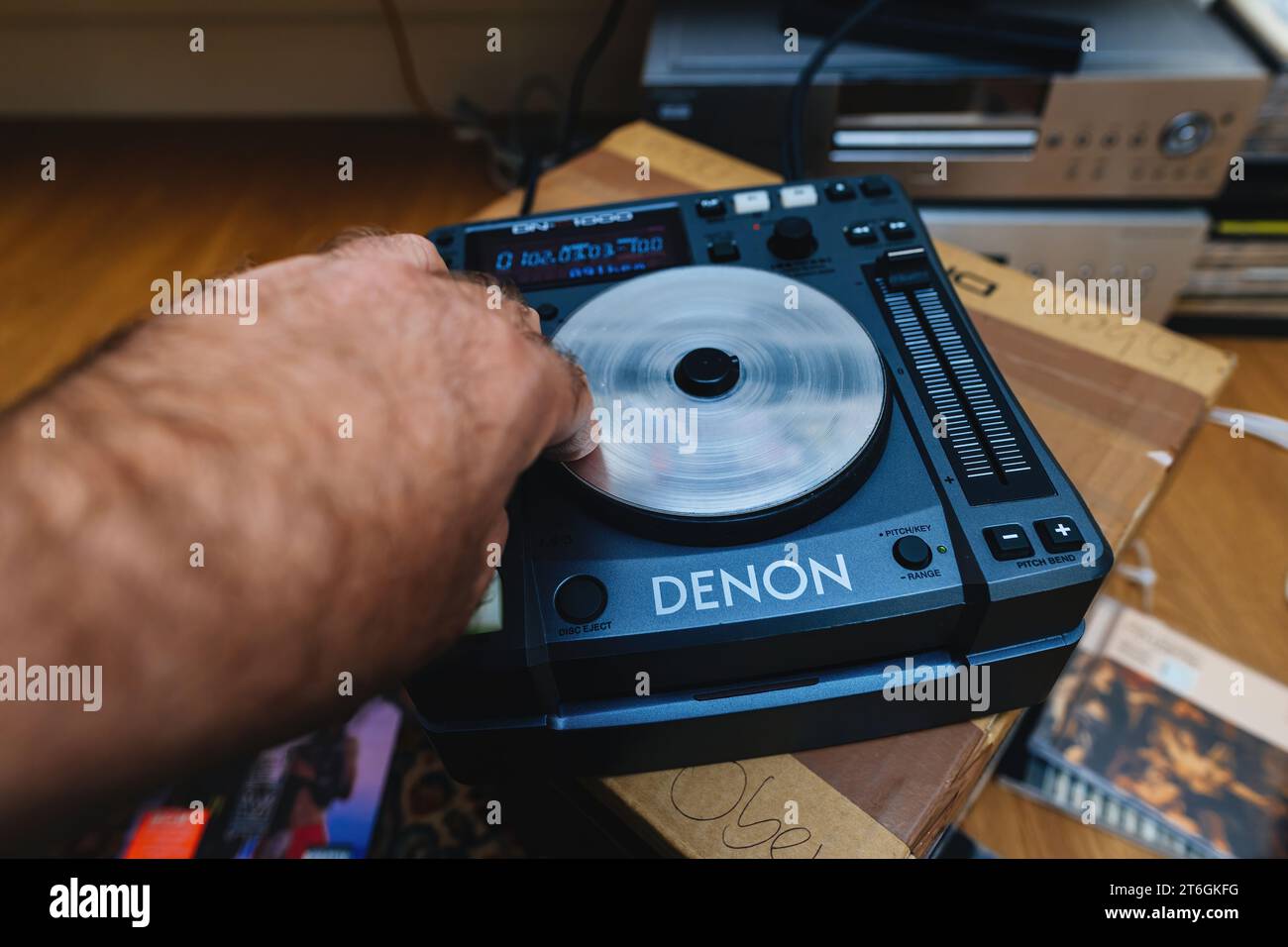 Paris, France - Oct 24, 2023: A DJ's skillful male hand performs a scratching technique on the new Denon Professional DN-S1000 mixing deck controller Stock Photo