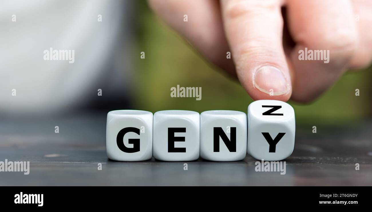 Hand turns dice and changes the expression 'GEN Y' to 'GEN Z'. Stock Photo