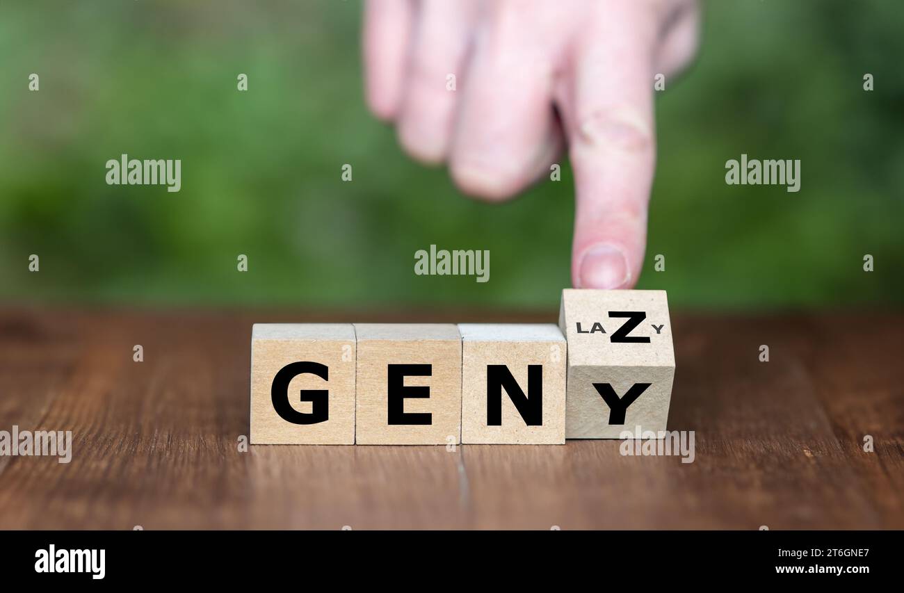 Symbol for a lazy life style of people from Generation Z. Hand turns cubes and changes the expression 'GEN Y' to 'GEN Z'. Stock Photo