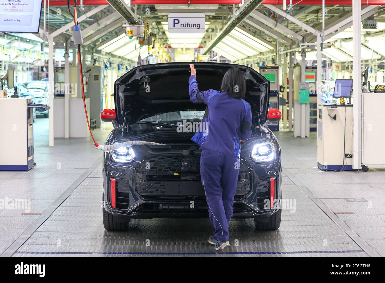 10 November 2023, Saxony, Leipzig: An employee at the BMW Group plant ...