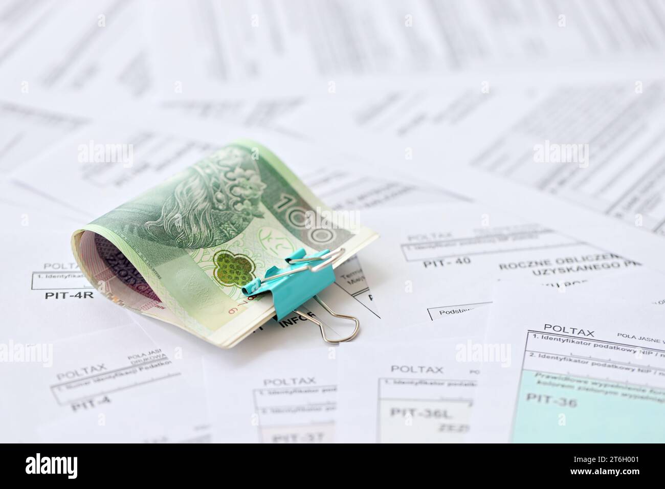 Polish zloty money PLN on big amount of polish PIT, CIT and VAT tax forms close up. Accounting
