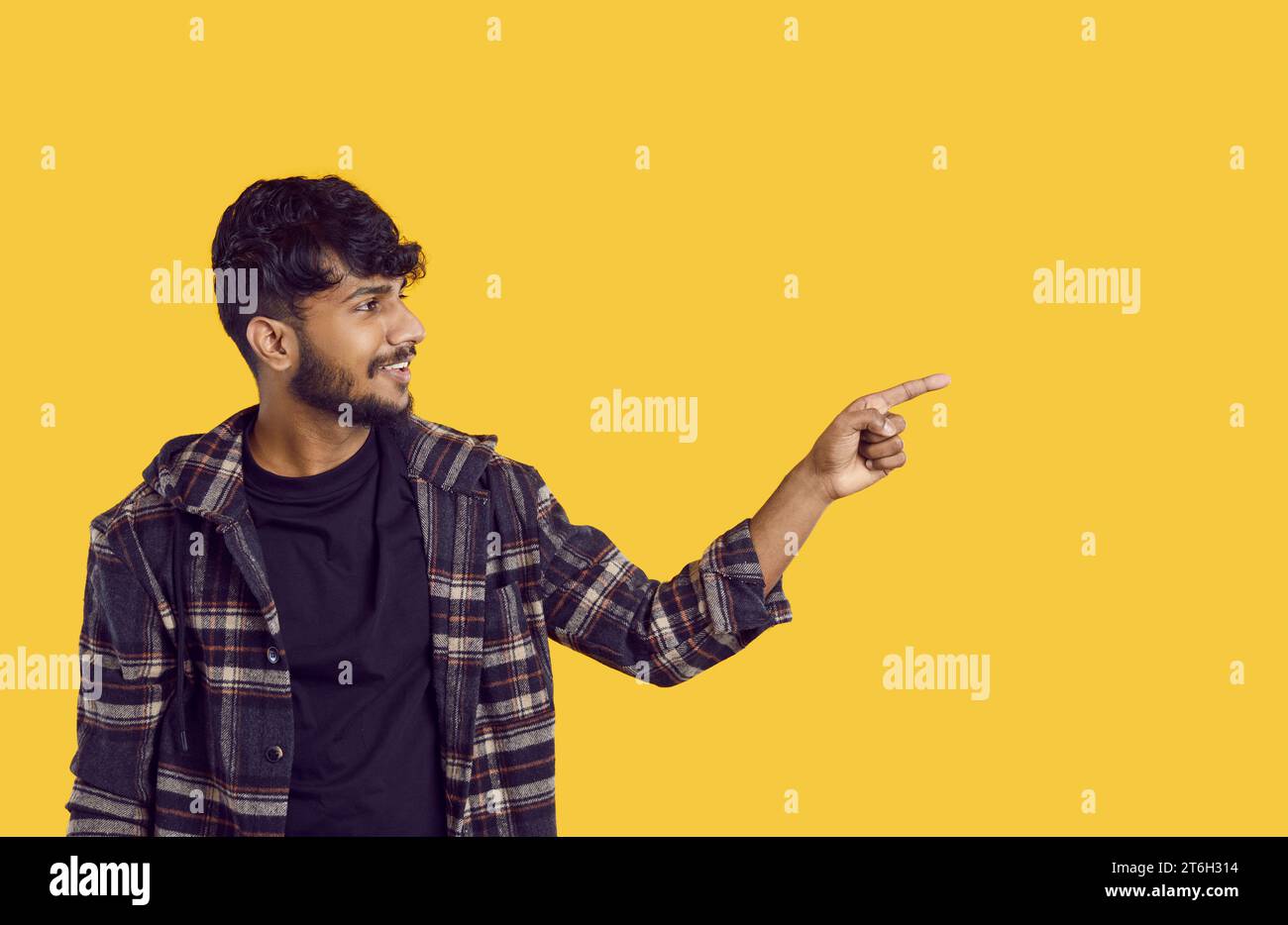 Happy positive young indian man pointing aside with finger hand gesture at copy space. Stock Photo