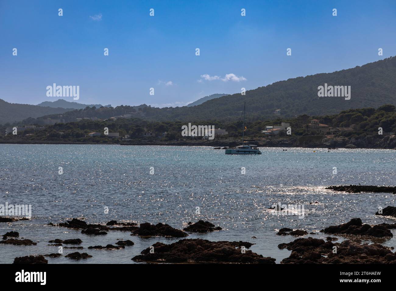 Sailing boat in back light in the bay of Cala Rajada, island of Mallorca, Spain Stock Photo