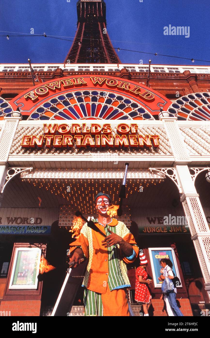 A clown juggling fire torches outside Blackpool Tower, Lancashire, England, UK Stock Photo