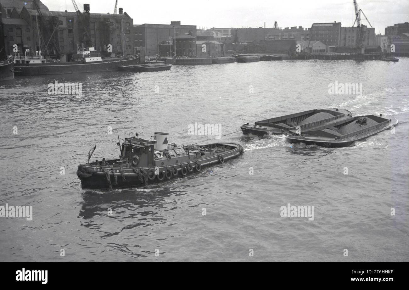 1950s, historical, a steam tug, initials B & D on side, pulling two barges loaded with freight, raw materials, on the river Avon at Bristol docks, England, UK. Stock Photo