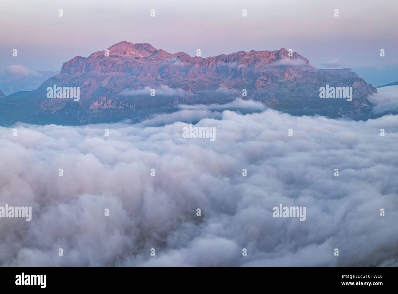 Italy, Veneto, province of Belluno, the Sella mountain group (side between the provinces of Belluno and Bolzano) emerging from a carpet of clouds at dawn, Dolomites Stock Photo
