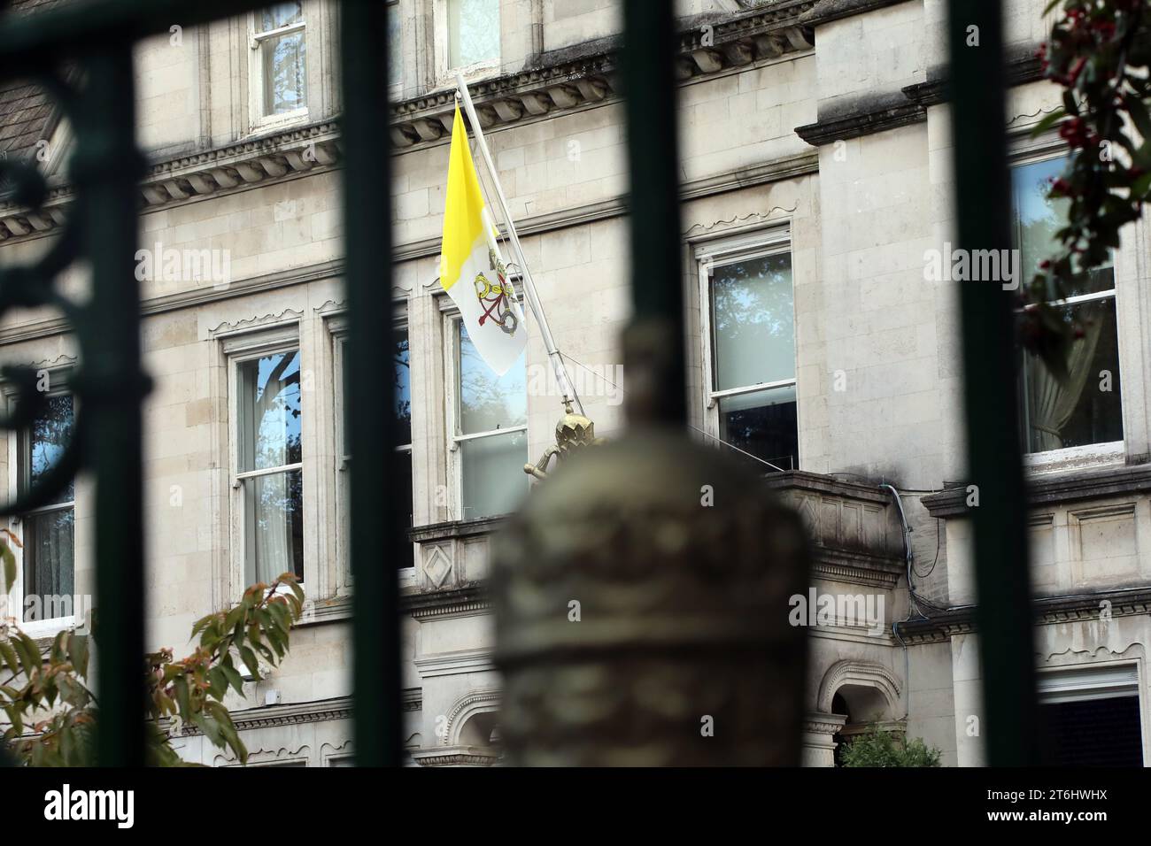 The flag of the Vatican, seen through the gates of the Vatican’s embassy in the UK – officially the Apostolic Nunciature to Great Britain, in Wimbledo Stock Photo