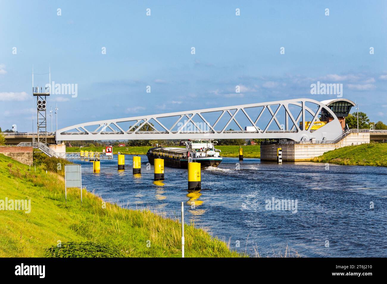 Cargo ship extremely narrowly passes under a road bascule bridge above the Hunte fairway. Stock Photo