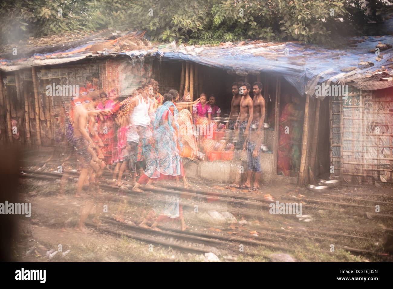 Family in front of their dwelling in the reflection of a broken mirror