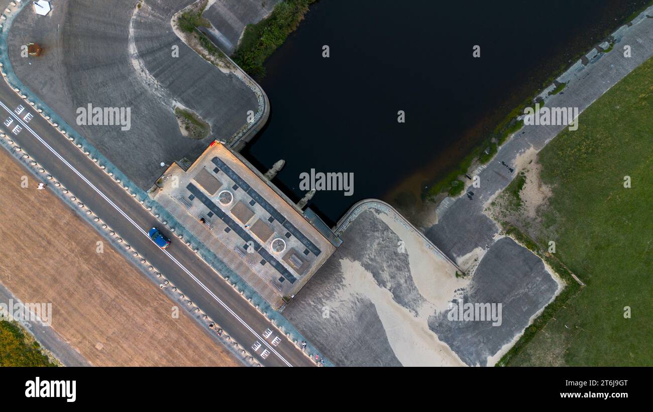 Beautiful view from above to the dam between the river and the North Sea. View from a quadrocopter to a car, road, a beach and a clearing with green g Stock Photo