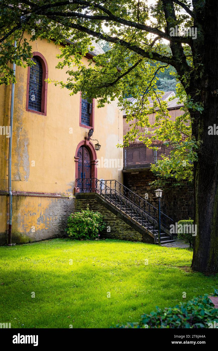 East side of St. Nicholas Church in Bacharach, Catholic parish with public library, romantic garden with high stairs, Stock Photo