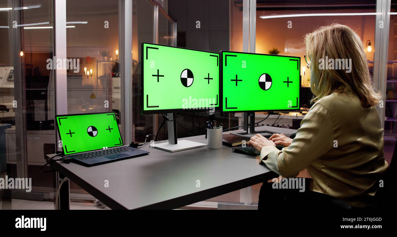 Woman Using Laptop on Office Desk with Computer Screen Stock Photo