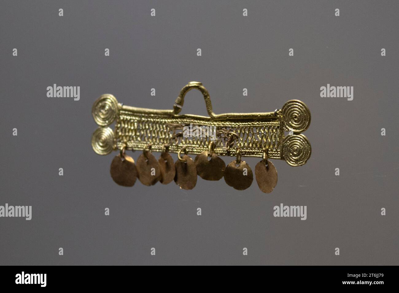 Beautiful small ear ring golden indigenous piece at colombian golden museum Stock Photo