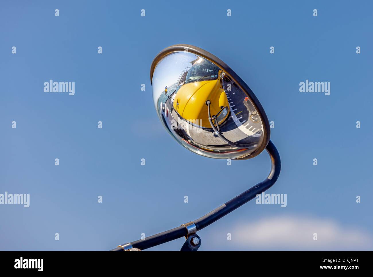 Detail of a convex mirror on a school bus reflecting the front end of
