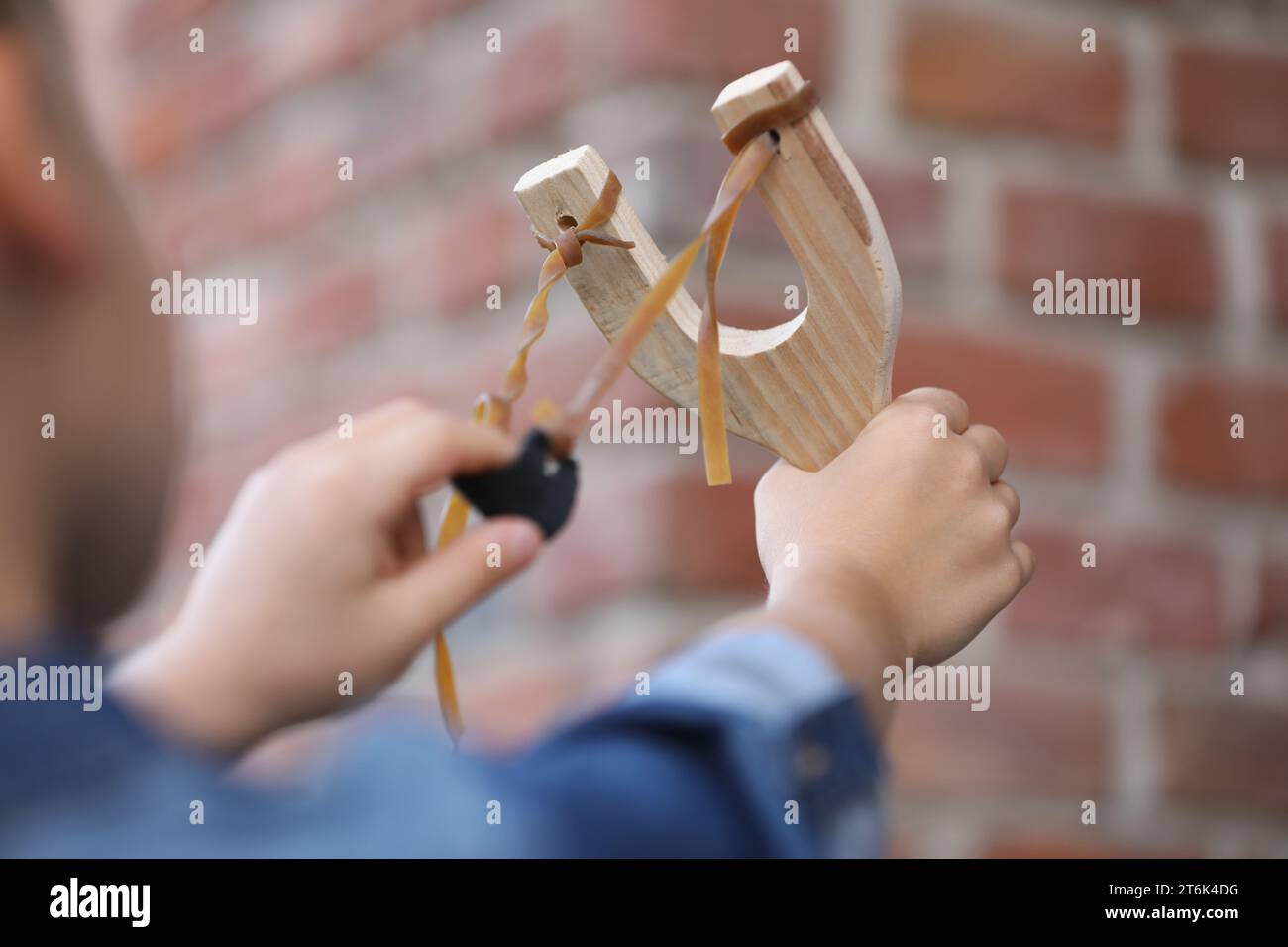 Little girl playing with slingshot outdoors, closeup Stock Photo