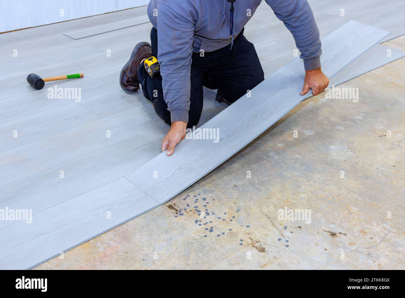 During construction of new home construction worker installed vinyl laminate flooring in room Stock Photo