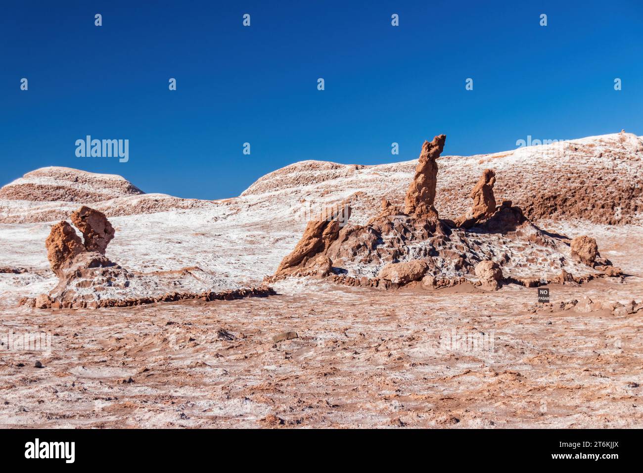 Tres Marias salt formations in the Valle de la Luna in the Atacama Desert, Chile. The sign reads 'No Pasar' - warning tourists not to enter the area. Stock Photo