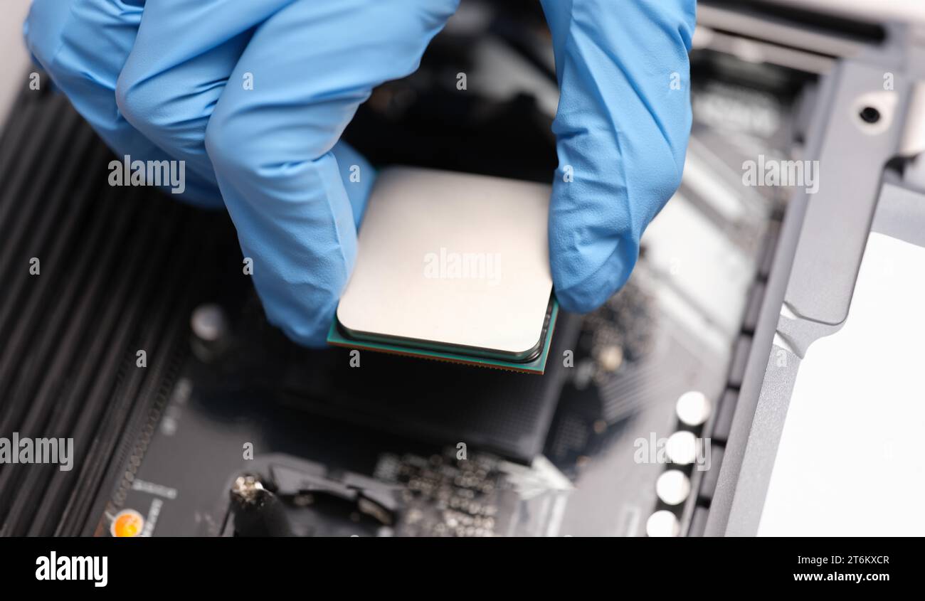 Technician examines microprocessor chip on PC motherboard Stock Photo