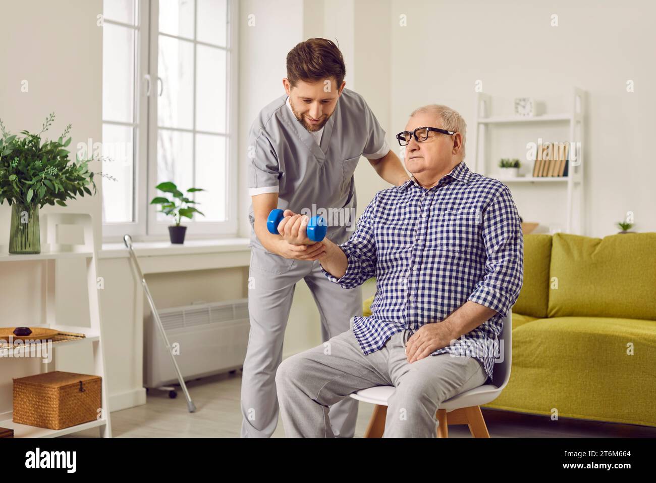 Senior man doing using exercise using dumbbells with support from a ...