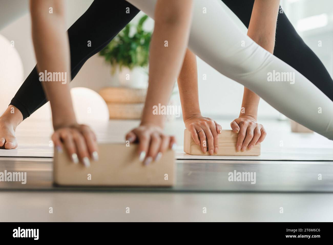 Close-up of female hands and feet practicing yoga using yoga blocks to support their body. Women's Health Stock Photo