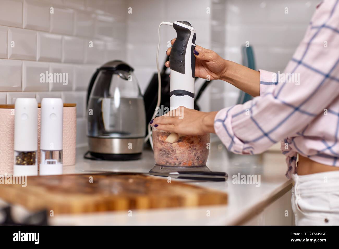 woman using blender and grinding meat. Preparation of minced meat Stock