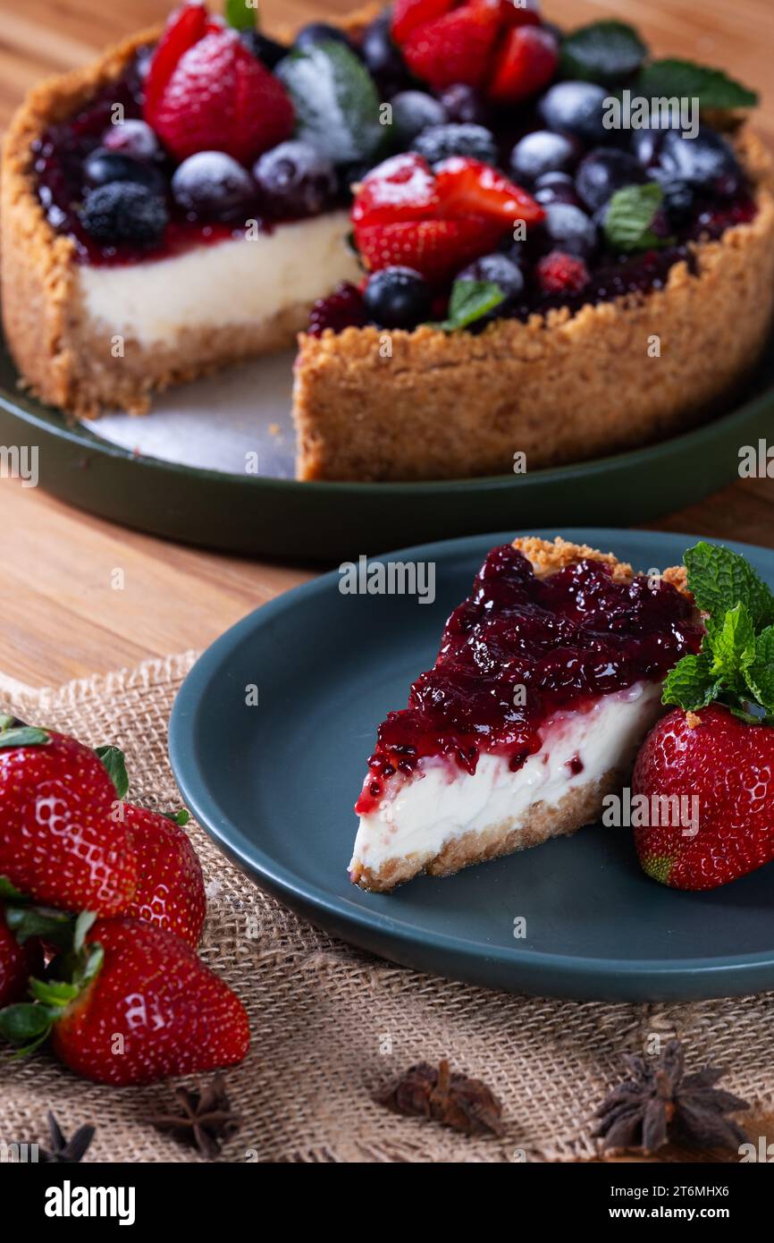 a slice and sweet pie with berries behind. Stock Photo