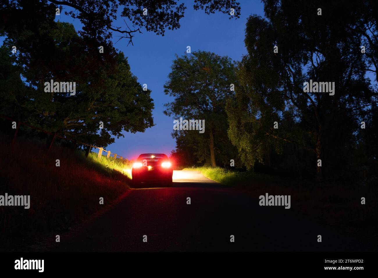 A mysterious car, parked on a country road on a summers night in a ...