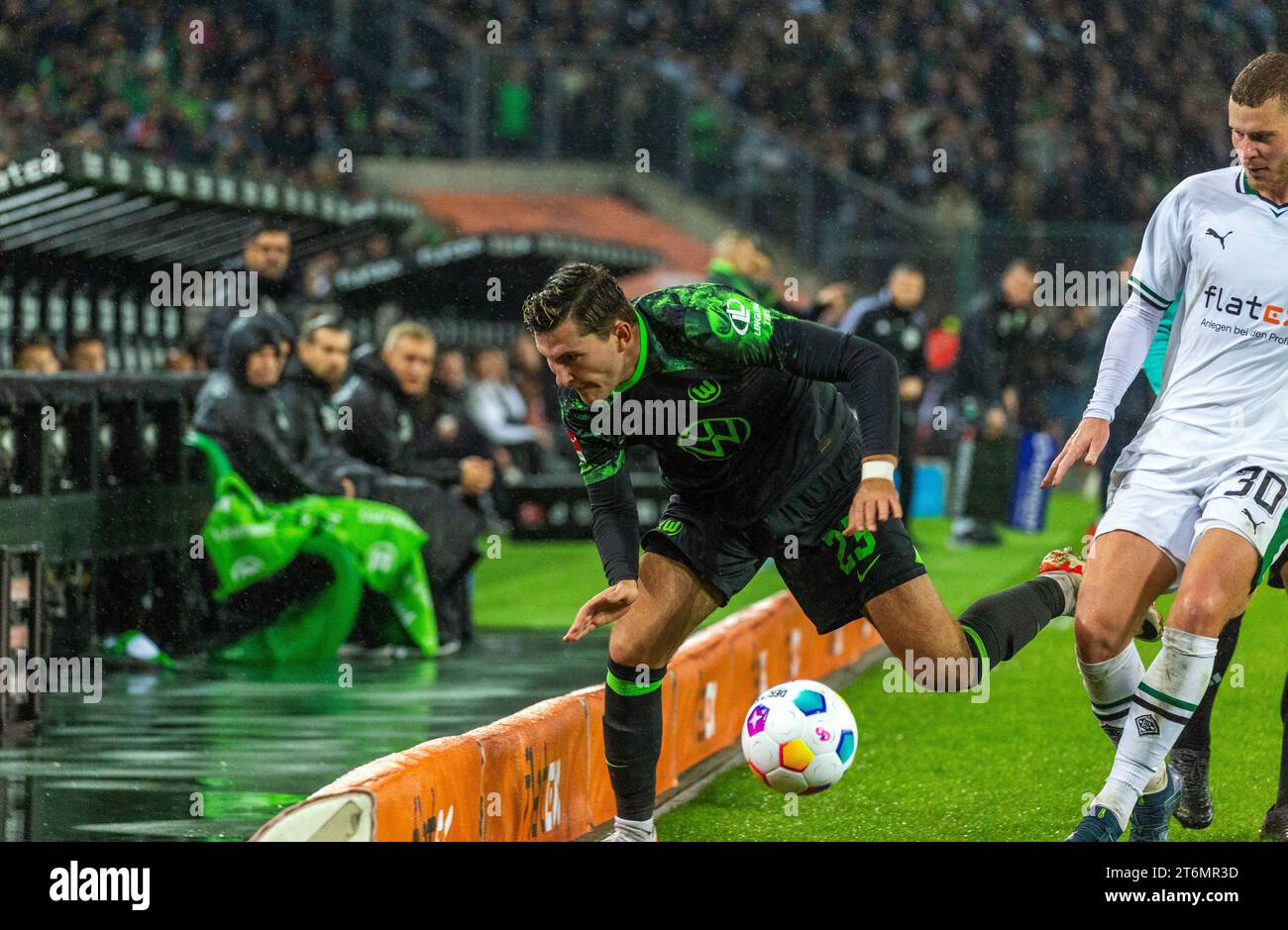 sports, football, Bundesliga, 2023/2024, Borussia Moenchengladbach vs. VfL Wolfsburg 4-0, Stadium Borussia Park, scene of the match, after a tackling by Nico Elvedi (MG) right Jonas Older Wind (Wolfsburg) left falls over the pitch boards, DFL REGULATIONS PROHIBIT ANY USE OF PHOTOGRAPHS AS IMAGE SEQUENCES AND/OR QUASI-VIDEO Stock Photo