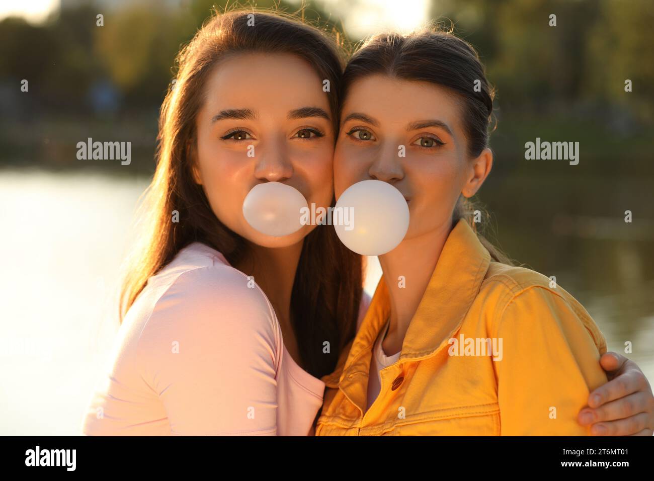 Beautiful young women blowing bubble gums outdoors Stock Photo Alamy