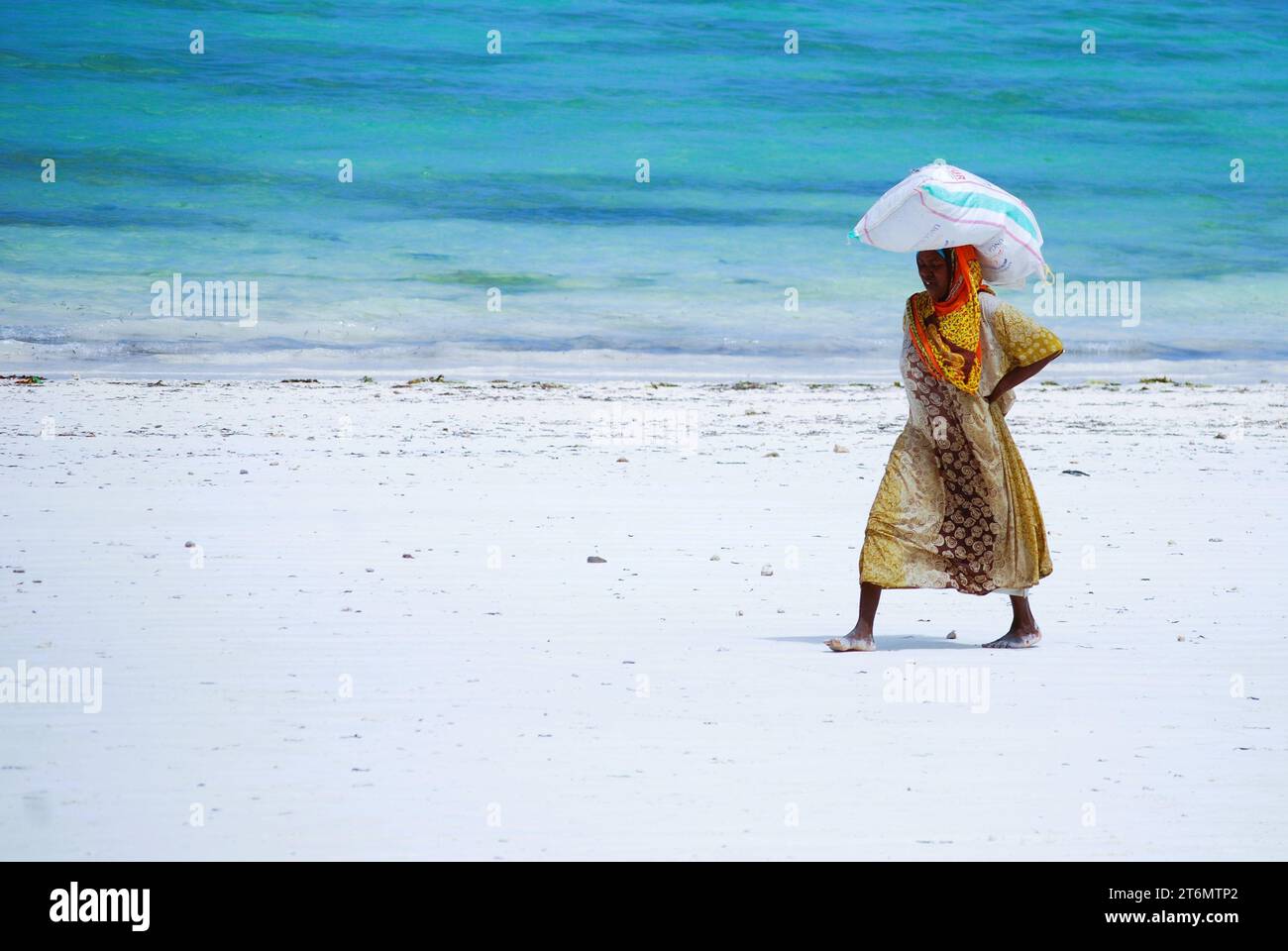 Paje Beach, Zanzibar Island, Southeast Africa, Local woman walking on the Beach Stock Photo