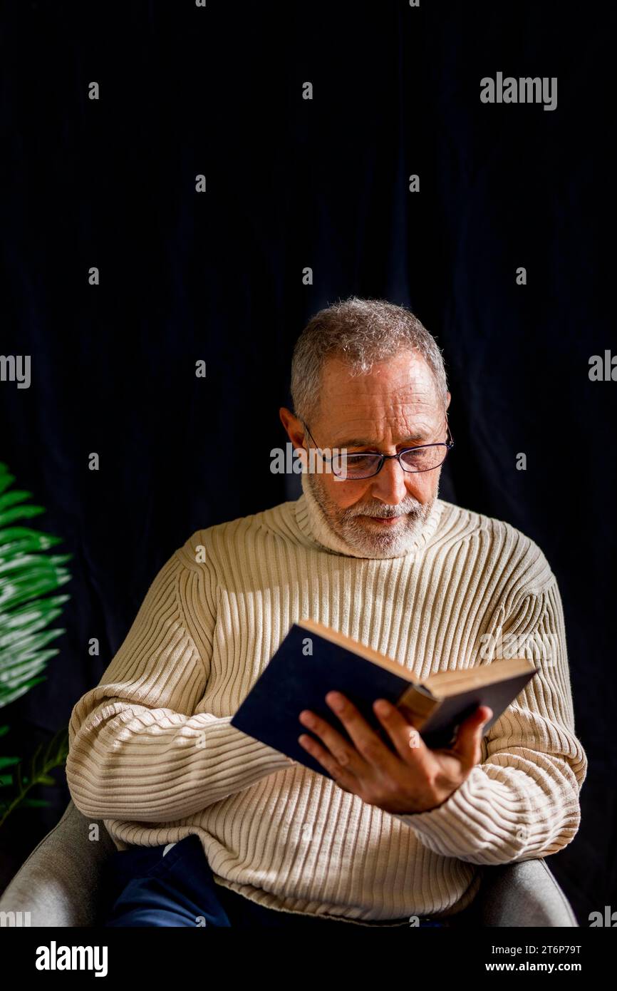 Elderly man glasses reading book Stock Photo