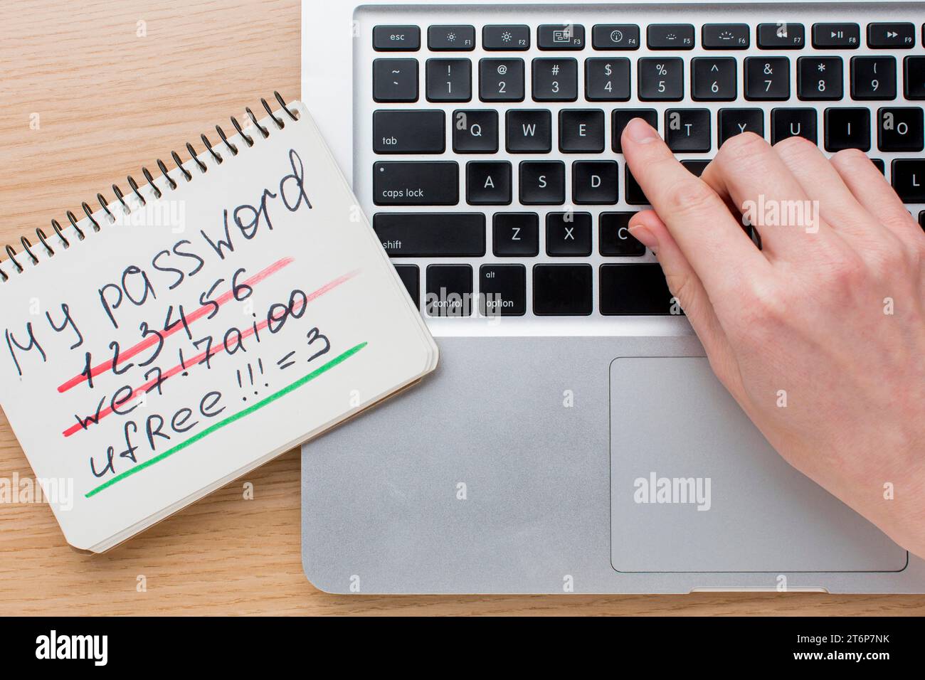Flat lay laptop with hands notebook with password information Stock Photo