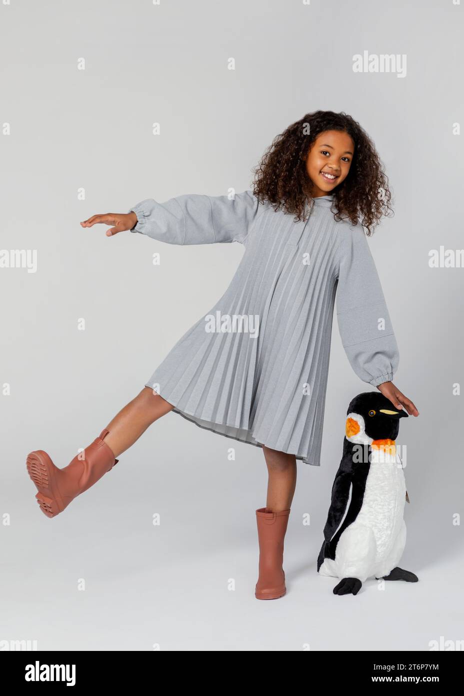 Full shot happy girl posing with penguin Stock Photo