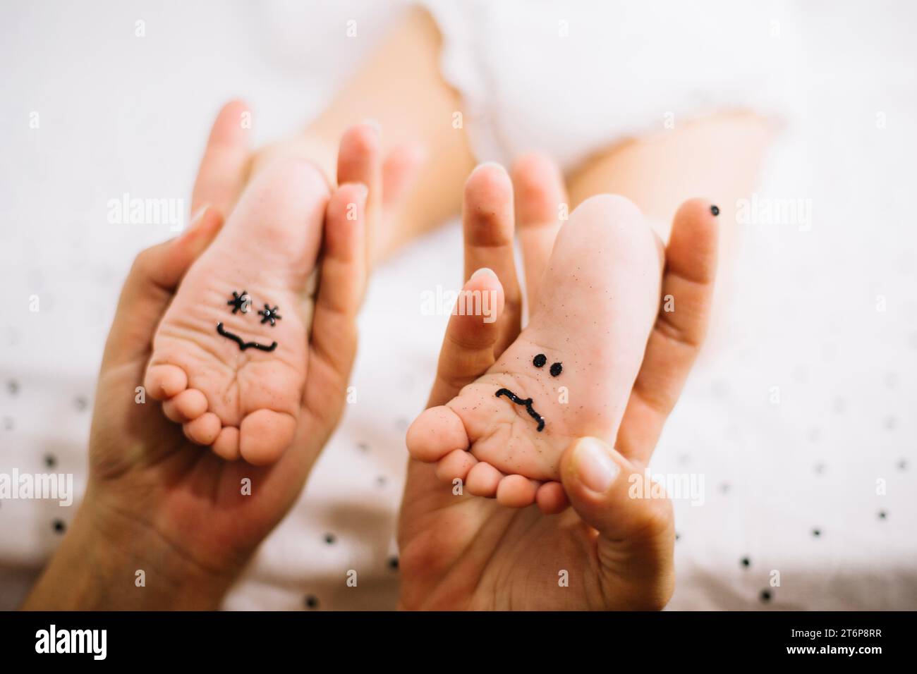 Mother holding feet baby with smileys Stock Photo