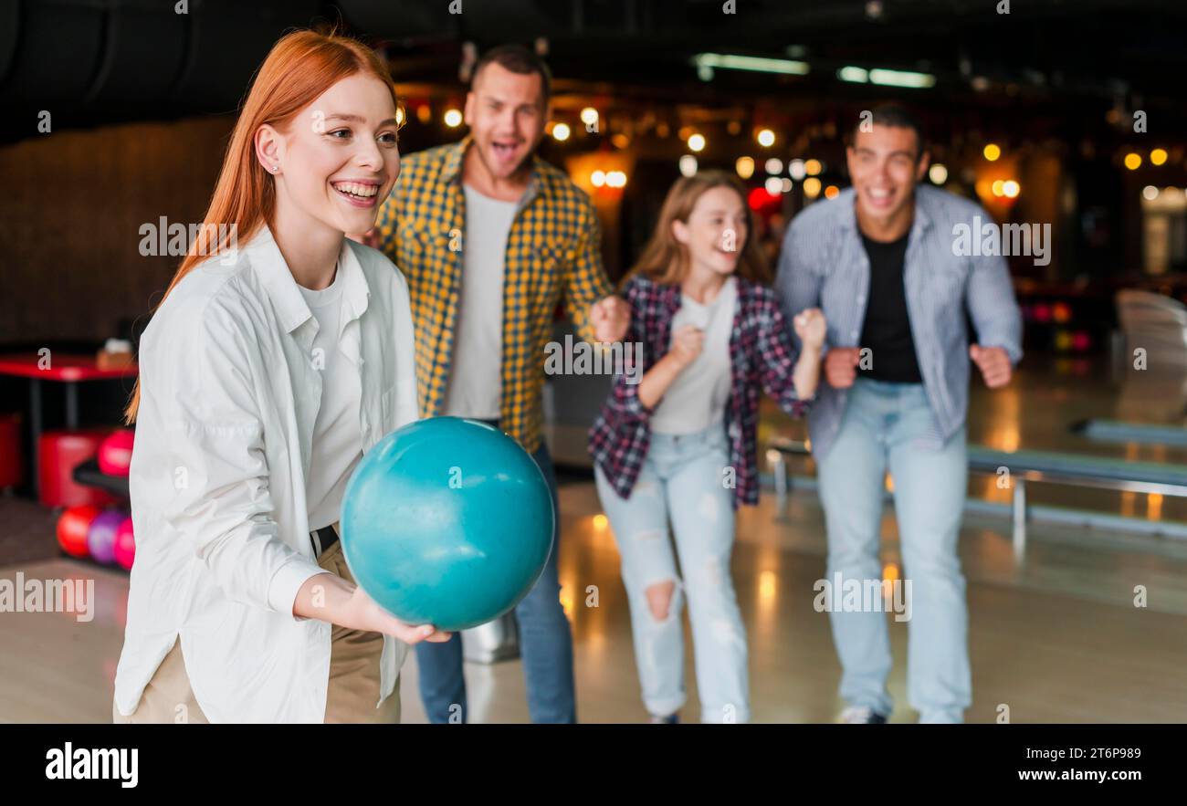 Redhead woman throwing turquoise bowling ball Stock Photo Alamy