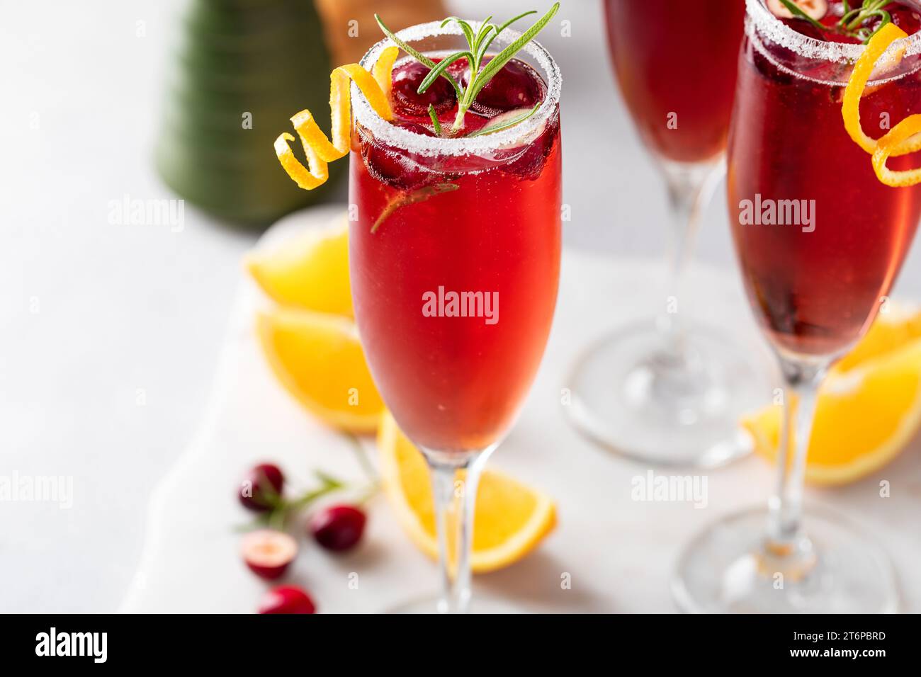 Christmas mimosas with cranberry juice and champagne or sparkling wine, festive Christmas cocktails garnished with orange peel twist Stock Photo