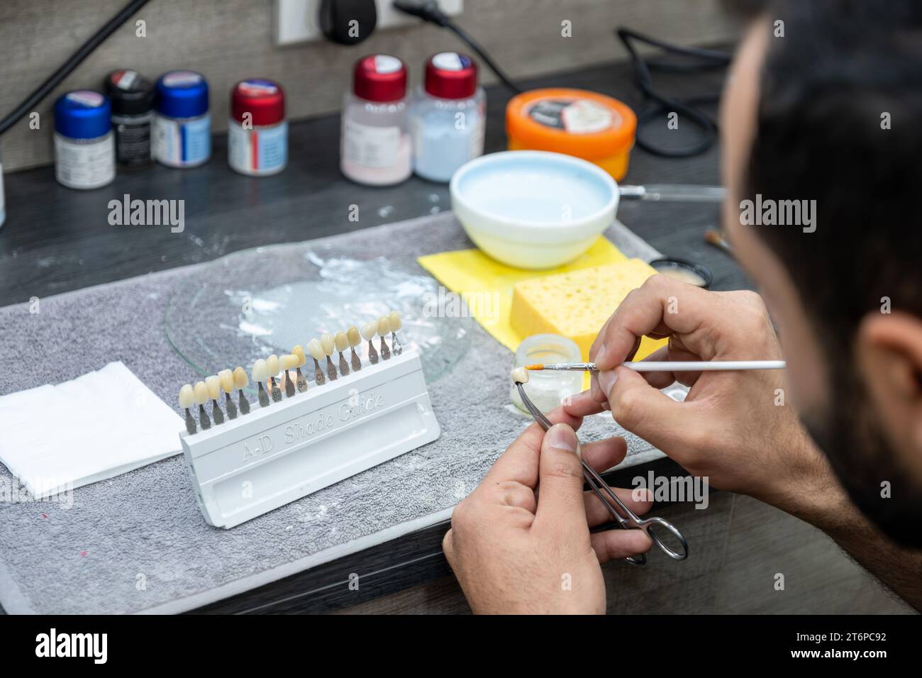 male checking AD shade guide for tooth crowns to select the proper