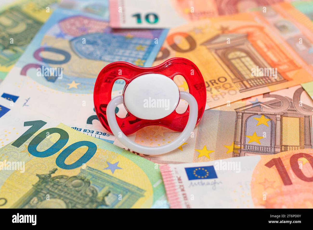 Childfree, Contraception and Birth Control Concept: Baby Pacifier on the Euro Banknotes. Having Children is Expensive and Unprofitable Stock Photo