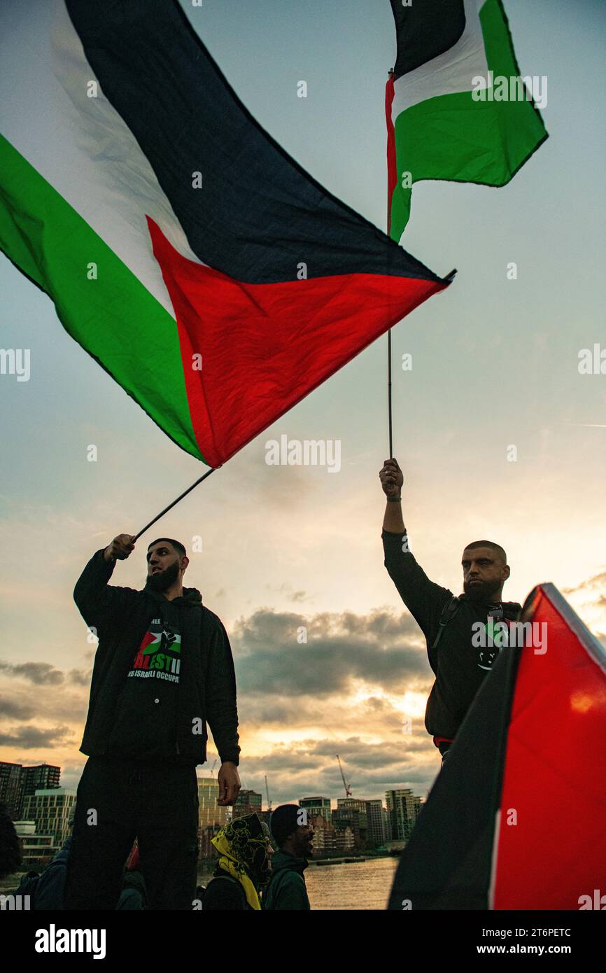London, UK. 11 November, 2023. Palestinian flags waved on Vauxhall Bridge at the end of the pro Palestinian march in central London  at dusk Stock Photo