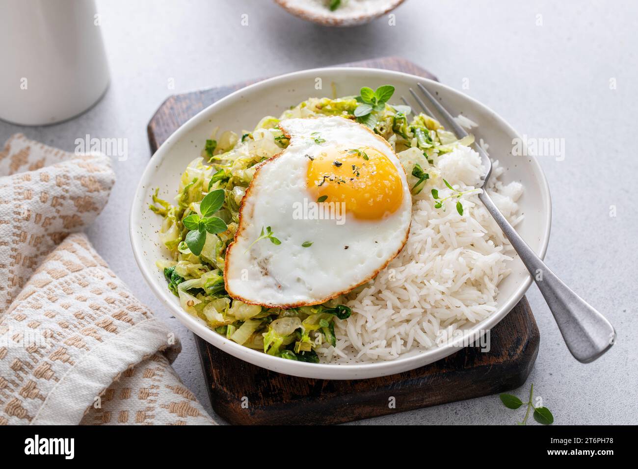 Rice bowl with sauteed cabbage and fried egg, healthy lunch or ...